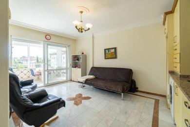Mermer zeminli, balkon erişimli, konforlu oturma alanlarına ve sıcak, davetkar bir atmosfere sahip aydınlık Alanya oturma odası.