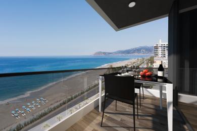 Şüşə məhəccərli Alanya mülkünün eyvanı, gözəl çimərlik və okean mənzərələri, parlaq gün işığı təklif edir.