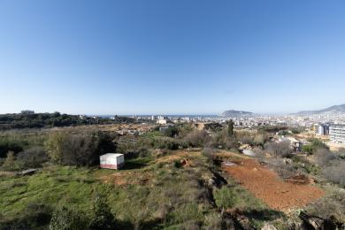 Uitzicht op een woning in Alanya met een panoramisch landschap met uitzicht op de stad, de zee en de bergen onder een helderblauwe hemel.