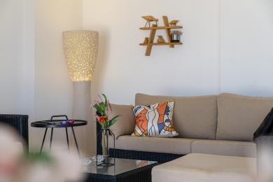 Alanya fastighet vardagsrum med en neutral soffa, dekorativ kudde och unik perforerad golvlampa, vilket skapar en mysig atmosfär.