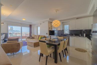 Sala de estar e jantar moderna em Alanya com cozinha elegante e vista para a cidade.