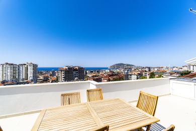 Vedere de pe terasa de pe acoperiș dintr-un apartament din Alanya, Turcia, oferind priveliști uimitoare asupra orașului și asupra oceanului pentru un stil de viață relaxat în aer liber.