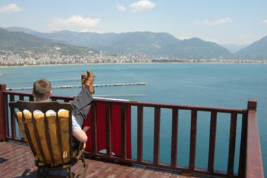 Alanya woning balkon met houten dek, reling en prachtig uitzicht op zee en de bergen.