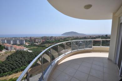 Proprietate în Alanya cu balcon cu balustrade de sticlă, podea cu gresie și vedere panoramică asupra orașului și a mării.
