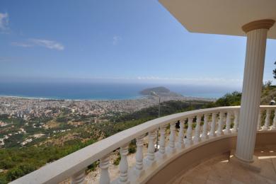 Balcón de propiedad en Alanya con balaustrada de mármol que ofrece vistas panorámicas de la ciudad y el mar Mediterráneo.