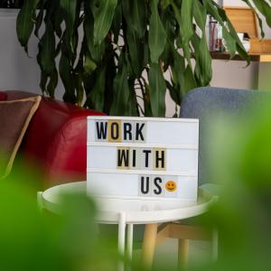 Современное офисное помещение в Алании с вывеской "Work With Us", приглашающей к сотрудничеству и росту.