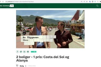 Alanya, Türkei: Zwei Männer gehen am Hafen entlang, mit Bergen und einem Boot im Hintergrund.